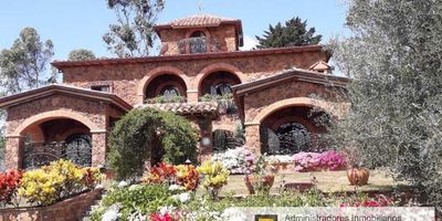 Vendo Excepcional Villa Toscana en la Mesa de Los Santos, en el sector campestre más exclusivo, tranquilo y seguro de Santander  Colombia. Construida en conjunto cerrado sobre terreno de 3.350 m2 con casa principal, casa de huéspedes y generosos patios, es una obra de arte que rinde homenaje al estilo típico italiano medieval de la zona vinícola de Siena, con acabados importados, pisos en Cotto Fiorentino, cerámica pintada a mano, chimenea en mármol de Carrara, terrazas, balcones, arcos y bóveda. Los muros en piedra y ladrillo rústico moderan el calor y el frío mantienendo la casa en una temperatura ideal. Posee amplias zonas verdes con jardines, flores, frutales, fuentes, kiosco, horno artesanal y zona de BBQ. Piso 1 Cocina, Sala, Comedor, Cuarto de despensa, Baño. Piso 2 Dos alcobas con clóset, baño familiar, alcoba principal con clóset y baño privado, balcón. Piso 3 Estudio  Habitación con balcón.  ESCUCHAMOS OFERTAS.