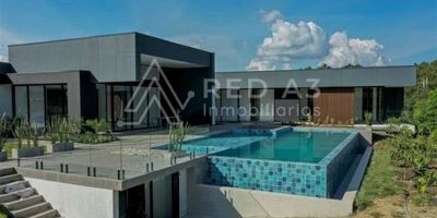 Proyecto localizado en una de las zonas de más alta valorización de la ciudad de Pereira como lo es la zona de Cerritos. Cuenta con vías de acceso totalmente pavimentadas y a tan solo 20 minutos del centro de la ciudad.

La vivienda de 770 m² aproximadamente está diseñada bajo el concepto arquitectónico minimalismo, basado en la sencillez y la simplicidad de cada espacio y forma. Su ingreso por medio de una puerta con una altura de 4,3 metros lleva a un hall frente a un jardín y junto a este el baño social, sala-comedor y cocina estilo loft, la zona de ropas, habitación de servicio y despensa tienen un ingreso independiente desde el parqueadero saliendo por la cocina. La parte privada se compone por una sala de cine, dos habitaciones auxiliares, cada una con baño, vestier y aire acondicionado, y habitación principal con baño, vestier y jacuzzi, además de una zona prevista para futura ampliación de una cuarta habitación.

La zona exterior cuenta con un lote de 3824 m² con zonas verdes y jardín, piscina con jacuzzi, chimenea y desde este punto se puede apreciar parte del lago que es de uso común del condominio. Parqueadero cubierto para 2 vehículos.

*Acabados de lujo.