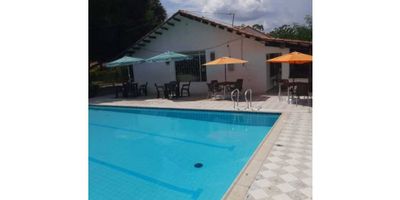 Te presentamos esta espectacular finca en venta ubicada en Ricaurte, Cundinamarca, un lugar tranquilo y rodeado de naturaleza que te permitirá desconectarte de la ciudad y disfrutar de la vida campestre. Con un área construida de 580 M2 y un área privada de 1600 M2, esta propiedad cuenta con amplios espacios y una excelente distribución para que tú y tu familia puedan vivir cómoda y placenteramente.

Con un total de 6 alcobas y 5 baños, esta finca es ideal para familias numerosas o para aquellos que disfrutan de recibir visitas. Además, cuenta con 6 garajes, por lo que no tendrás que preocuparte por el espacio para tus vehículos. Pero eso no es todo, esta propiedad también es amigable con tus mascotas, así que podrás tenerlas contigo sin ningún problema.

Al ingresar a la finca, te encontrarás con un hermoso jardín y una acogedora zona de barbacoa, perfecta para reuniones y eventos al aire libre. En su interior, está completamente amoblada y cuenta con armarios empotrados en todas las habitaciones, lo que te brindará todo el espacio necesario para almacenar tus pertenencias de forma organizada.

La cocina es uno de los puntos más destacados de esta propiedad, ya que cuenta con una barra estilo americano y está equipada con cocina integral y electrodomésticos modernos. Además, tiene un comedor auxiliar y una despensa para facilitar el almacenamiento de tus alimentos. La luz natural y la doble ventana en toda la finca le dan una sensación de amplitud y luminosidad, lo que hace que sea un espacio muy acogedor.

La finca también cuenta con una habitación de servicio, ideal para recibir personal doméstico. Algunas de las comodidades internas que destacan en esta propiedad son su hall de alcobas y suelos de cerámica / mármol, lo que le da un toque de elegancia y lujo. Siempre es importante mencionar que la misma propiedad cuenta con vigilancia y seguridad, y un acceso por portería, lo que te brinda tranquilidad y protección.

Si eres amante d