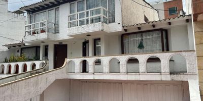 ¡Excelente oportunidad de inversión! Casa de tres niveles actualmente rentando, con amplios y cómodos espacios. Cuenta con tres alcobas, la principal con baño privado, además de baño social y baño de servicio, para un total de cinco baños. Dispone de estudio, sala y comedor independientes, cocina equipada con estufa y calentador eléctricos, zona de lavandería, chimenea funcional y pisos en madera y cerámica. La propiedad incluye terraza cubierta, dos garajes y una generosa área construida de 350 m². Es una casa bifamiliar, ubicada en una zona estratégica cerca de vías principales, centros comerciales y con fácil acceso a TransMilenio.