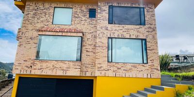 Codigo 16978. Encantadora casa, ubicada en una parcelación segura en el pueblo de La Calera, te ofrece una experiencia de vida única. Con un lote de 332 m2 y una construcción de 400 m2, esta propiedad cuenta con espacios amplios y acogedores. Disfruta de la calidez de la sala con chimenea, comedor, cocina cerrada con espacio para comedor auxiliar y un conveniente cuarto y baño de servicio. Además, encontrarás una biblioteca estudio, zona de ropas, 2 parqueaderos, 3 habitaciones, cada una con su baño privado