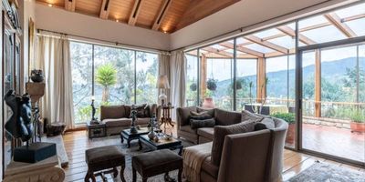 PADS te presenta en venta una magnífica casa ubicada a solo siete kilómetros de la ciudad de Bogotá. Cuenta con espaciosa abiertos donde podrás vivir con tranquilidad y en permanente contacto con la naturaleza en un condominio seguro y rodeado de un espléndido paisaje con un bosque nativo que te permitirá ejercitarte y respirar aire puro. 

La casa cuenta con una encantadora zona de ingreso con luz natural, donde se combina perfectamente sus pisos en cerámica con detalles de madera, logrando ambientes muy acogedores.  La sala es muy amplia. Allí podrás utilizar una gran chimenea los días fríos mientras disfrutas una increíble vista gracias a sus amplios ventanales. En frente de la zona social se encuentra una hermosa terraza cubierta la cual fue diseñada  en madera y vidrio, con una vista maravillosa que aporta además de iluminación y calidez un ambiente alegre y acogedor a la vivienda.	

La casa tiene una amplia cocina, con isla central y espacio para comedor diario...