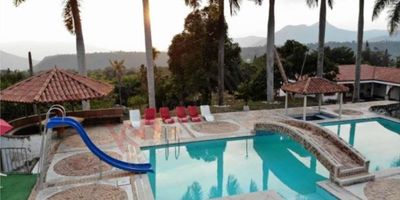 Codigo 8956. Hermosa finca de descanso, cuenta con Casa Principal, dos cabañas para huéspedes, una casa de muñecas, Zona de BBQ, Casa Club con dos baños, Casa de Mayordomo, tres Depósitos, Caballerizas, Galpón para aves, Tanque, Cuarto de bombas, Tanque elevado, Planta de tratamiento, Palco, Cancha múltiple, cancha de tenis, cancha de futbol, Turco, Piscina con ducha, Jacuzzi, Cancha de Tejo, amplia zona de parqueo para mas de 10 carros.