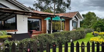 Codigo 11691. Hermosa casa campestre de un solo piso en venta en Vereda Juaica Tabio de 232 m2 en un lote de 2.747 m2, zonas verdes ideales para huertos, cuenta con 4 habitaciones cada una con baño privado, sala y comedor independente, cocina integral americana, hall de alcobas, lavandería, terraza y zona BBQ, 2 depósitos, parqueadero hasta para 6 vehículos (2 cubiertos con pérgola), tanque de reserva de 34.000 litros, acueducto veredal, calentador solar, el acceso a la propiedad con portón eléctrico, vigilancia nocturna. Su ubicación le permitirá disfrutar de la naturaleza que le rodea, zonas tranquilas, además cuenta con excelentes vías de acceso y cercanía a centro de Tabio y Tenjo. Admon. $245.000 COP