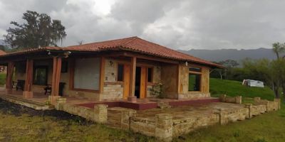 Se vende una hermosa finca de aproximadamente 8 fanegadas en Moniquirá. La propiedad cuenta con una espaciosa casa de 360 m2 de área construida, que incluye 4 habitaciones, 3 baños, sala, comedor, cocina, patio de ropas y un amplio espacio de estar. Además, está equipada con modernas instalaciones como zonas húmedas, gimnasio, piscina al aire libre y zona de barbacoa.

La finca ofrece una experiencia única, ya que cuenta con una laguna ideal para practicar canotaje, un río cercano y nacederos de agua que brindan un entorno natural maravilloso. Para garantizar la seguridad, cuenta con sistemas de vigilancia CCTV, alarmas y reflectores solares para iluminar el área en la noche.

Además, la propiedad es sostenible y amigable con el medio ambiente, ya que dispone de un calentador de agua de 200 litros y paneles solares. La construcción se realizó con materiales de alta calidad, como piedra, estructura de bloque, adobe rústico y vitrificado.