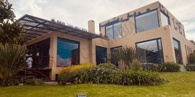 Codigo 14734. ¡Arrienda esta espectacular casa en La Calera! Con 2,100 m² de terreno y vistas panorámicas al valle de Sopo y montañas de Chingana. 4 habitaciones con baño propio más habitación de servicio. Amplios espacios como sala, comedor con chimenea, family room y estudio en madera. Cocina en isla, zona de lavado, depósito y más. Tanque de reserva, hidroneumático, 6 parqueaderos y áreas húmedas. ¡No te lo pierdas!