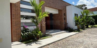 El Inmueble: En un lote de 1600 metros cuadrados encontramos una amplia casa de 360 metros distribuidos en tres habitaciones, la principal de ellas con baño privado  y vestier independiente, dos habitaciones auxiliares y un generoso espacio a manera de biblioteca, un estudio  haciendo esquina de la casa con puertas de piso a techo  lo que permite un espacio semiabierto al jardín; sala y comedor independientes, una chimenea adyacente con diseño contemporáneo a juego de la arquitectura de la casa; cocina abierta con mobiliario italiano y dotada de modernos electrodomésticos, la casa rodeada de una espaciosa zona verde donde encontramos un deck con vista hacia la cuenca del río Consota y hacia la cordillera, pudiéndose observar el nevado del Ruiz en días despejados.