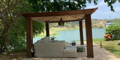 UNA CASA DE CRISTAL FRENTE AL LAGO

Respira paz y armonía, conexión con la naturaleza, simplicidad y confort.

EXCLUSIVIDAD

El lujo de un hogar adornado con el entorno natural de sus lagos con la posibilidad de acceder a los servicios del club con un campo de golf de 18 hoyos, ubicado a cinco minutos de la ciudad de Barranquilla con todos los servicios complementarios para tu familia: náutica, deportes, (tennis, football, hípica, natación), zonas húmedas, restaurante, etc.

Casa diferente, moderna y llena de luz natural construida sobre un lote de terreno de 1.454.90M2, se levantaron en dos pisos 846.00M2, distribuidos así:

En el primer nivel con imponente doble altura un amplio foyer, toda la zona social para distribuir varios ambientes versátiles a tu gusto; terraza, piscina, cocina cerrada muy funcional; baño social, alcoba de huéspedes con baño incorporado.
