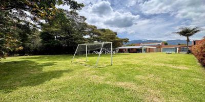 Codigo 18652. ¡Te presentamos esta espectacular Obra de Arte que cuenta con uno de los mejores lotes de la hacienda! Esta casa consta de 350m2 construidos habitables + 80m2 de terrazas, al ingresar a la propiedad se ubica la zona de parqueadero que alberga un espacio cubierto para dos vehículos y 6 o más descubiertos con una entrada de servicio que conduce a la cocina. Tras su puerta principal se aprecia la distribución de la casa donde permite tener toda la zona privada a parte de la zona social.Esta se conforma por un espacio cómodo de sala con chimenea, zona de tv, comedor amplio, baño social, cocina integral cerrada con barra americana, espacio de comedor auxiliar y una terraza, adicionalmente cuenta con zona de lavandería y cuarto y baño de servicio independiente.En cuanto a su zona privada consta de 3 habitaciones auxiliares con vestier y baño privado, sala de tv y la generosa habitación principal con terraza, amplio vestier y baño privado.¡Agenda tu visita ahora mismo y conoce esta excelente oportunidad de vivienda e inversión!