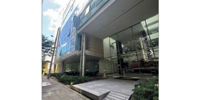 Oficina en arriendo de 83 m² ubicada en el barrio El Chicó, que destaca por sus ventanales de techo a piso que brindan amplia luz natural y una vista panorámica inigualable. Cuenta con pisos en madera laminada, luz LED, biblioteca y puerta de seguridad. Dispone de baño privado, cinco espacios independientes que pueden adaptarse para sala de juntas, dos garajes y un depósito. El edificio ofrece vigilancia 24 horas, circuito cerrado de TV y salas de reuniones, con una ubicación estratégica cerca de la Calle 100 y las carreras 7 y 11.
