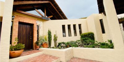 CODIGO 5969FR754 Venta de amplia y acogedora casa en el municipio de Cota, Vereda parcelas, con un área de doscientos cuarenta M2 mas dos depósitos y un cuarto acondicionado como gimnasio que suman otros cuarenta y cinco M2, dentro de un lote de mil cuatrocientos sesenta M2, la casa de un solo nivel cuenta con sala con chimenea y comedor independientes, terraza y jardín, cocina integral  tipo americano, ámplia zona de lavandería, habitación de servicio con baño privado, estudió, baño social, hall de alcobas, estar de alcobas con chimenea, dos habitaciones auxiliares de buen tamaño que comparten un baño, habitación principal con baño privado; dos parqueaderos cubiertos y aproximadamente espacio para otros cuatro parqueaderos; rodeada de un inmeso jardín, también cuenta con un invernadero para cultivo en casa; ubicada en una zona muy tranquila y segura de Cota el inmueble se encuentra dentro de un conjunto de 8 casas cada una con entrada privada y lote independiente; la apertura de la puerta del conjunto esta automatizada para el manejo desde la casa con CCTV. Transporte cercano, cerca a la variante Siberia-Cota, zonas de comercio y restaurantes; una gran oportunidad de disfrutar de la tranquilidad del campo muy cerca de la ciudad.  
