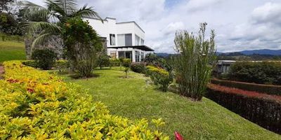 Esta magnífica propiedad se encuentra ubicada en una de las zonas más exclusivas y de mayor valorización del Oriente antioqueño, ofreciendo un entorno seguro, tranquilo y rodeado de naturaleza, ideal para quienes buscan confort, privacidad y calidad de vida. Diseñada con acabados de alta gama, amplios espacios interiores y exteriores, y una arquitectura moderna que combina funcionalidad y estilo. Área del lote 3000 m2. Área construida 418 m2, parqueaderos cubiertos. Amplio sótano cerrado con baño. La sala comedor es en doble altura con ventanales en gran formato en vidrio de 6 mm con vista panorámica. Cocina abierta con barra americana, mesones en mármol granate, gabinetes en cedro. Tres habitaciones, dos de las cuales tienen baño privado y vestier, la otra habitación con closet. Un baño social. Zona de ropas y habitación de servicio con baño. En el segundo piso una habitación con baño y closet, sala de música con chimenea. Inversión $2.690.000.000.