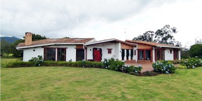 CODIGO 9149FR791 Se vende ESPECTACULAR casa en lote de una hectárea en Tenjo -Cundinamarca- (zona rural); la casa dispone de: Habitación principal con dos guardarropas y un baño amplio con jacuzzi y ducha; mas tres habitaciones cada una con baño privado, mas un baño social, un estudio grande, una sala de televisión y adicionalmante una habitación (con altillo) que puede ser utilizada como sala de juegos o gimnasio; cocina amplia con espacio exterior para asados, Sala, Comedor, y Salas de estar que funcionan como patios internos que anteceden las habitaciones; dos garajes cubiertos y una pequeña construcción anexa que funciona como lavandería. El lote de una hectárea tiene acceso vehícular en adoquín de gres, ámplias zonas verdes para el disfrute de toda la familia y de sus mascotas, árboles y arbustos nativos que dan mucha privacidad para los propietarios. Adicionalmente cuenta con espacio suficiente para tener huertas. La casa se encuentra ubicada en una zona rural del municipio de Tenjo al occidente de Bogotá, a 40 minutos del puente de guadua Calle 80 (Acceso principal a Bogotá), por lo que se puede tener una vida muy tranquila en la sabana y a la vez estar muy cerca de la ciudad; se puede tener conexión a los municipios cercanos como Tabio, Cajica, Chía, Cota, Subachoque a menos de 30 minutos de distancia.
