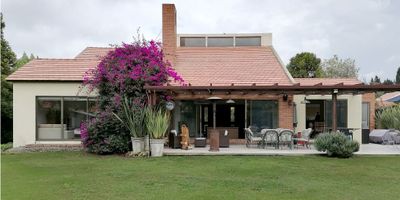 CODIGO  9150FR088 Se vende Espectacular casa en Guaymaral. Caracterizada por sus grandes ventanales, excelente iluminación natural a lo largo del día, y su perfecta y completa tranquilidad. La casa dispone de cuatro habitaciones de las cuales tres tienen baño privado, mas baño social; una zona de estudio grande y una sala de televisión; cocina amplia con comedor auxiliar y un gran comedor con capacidad para ocho personas; dos garajes cubiertos (además de cupo para otros tres vehículos), cuarto de depósito, cuarto y baño de servicio, y zona de lavandería; en cuestiones de seguridad cuenta con sistema de alarma y el conjunto con seguridad privada y varios puntos de control de acceso; también cuenta con zona de BBQ, salas de estar al aire libre y un gran jardín con casa de muñecas para niños y niñas. El conjunto residencial es muy selecto y cuenta con muy pocas unidades de vivienda, las cuales pueden disfrutar de grandes zonas verdes y mucha privacidad, volviéndose un espacio envidiable. Se encuentra ubicada en Guaymaral, por lo que se pueden ver muchas zonas verdes y disfrutar de mucha naturaleza; este sector está a menos de diez minutos del peaje de los Andes al norte de Bogotá.

