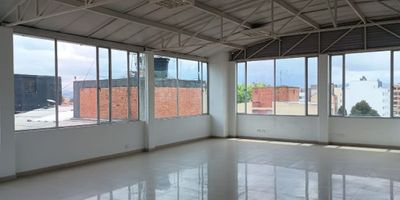 Excelente oficina de 100 m². Espacio abierto, cocineta, un baño, pisos en porcelanato, vista exterior y un garaje. Ubicada en edificio con ascensor, vigilancia 24/7, recepción, planta eléctrica y tanque de reserva. Muy cerca de la estación de TransMilenio Los Héroes, zonas comerciales y vías principales.