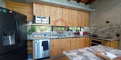 Vendo casa en parcelación jurisdicción del Carmen de Viboral, 226 mt² construidos y un lote de 3100mt², cerramiento en setos vivos, ingreso con placa huella, portón eléctrico, fachada cúbica diseñada por el arquitecto Felipe Uribe de Debut, tres alcobas, cuatro baños, siete closets, oficina y biblioteca, chimenea de leña y cuarto útil, cocina integral abierta con isla, estufa de inducción x4 y dos puestos eléctricos, despensa, dos deck, zona verde con árboles frutales, alarma de sensor dentro y fuera, la casa está levantada del terreno natural por cimientos, unidad con cámaras de seguridad, lagos, senderos ecológicos y portería 24 horas. Vende Activos y Bienes, Inmobiliaria experta en administración y arrendamiento de apartamentos, casas, locales, bodegas y oficinas en el Oriente Antioqueño, Medellín y toda el área Metropolitana. Información sujeta a cambios. Las imágenes de muebles, enseres, decoración y demás elementos son una referencia.