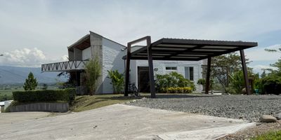 Casa de 300 m² en venta, situada a 5 minutos del área urbana de Tuluá, en un lote de 1.000 m² con vista panorámica de 360° sobre la zona rural de Tuluá.  Ubicada dentro de un conjunto cerrado que cuenta con portería y vigilancia 24/7, circuito cerrado de TV, vías internas pavimentadas y acceso desde la troncal del Occidente. La propiedad tiene tres habitaciones con baño, sala-comedor, baño social, cocina con bodega, patio de ropas, tres terrazas, jacuzzi y parqueadero para seis vehículos, dos de ellos cubiertos.