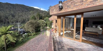 MAJESTUOSA CASA CAMPESTRE EN VENTA CON VISTAS PANORÁMICAS UBICADA EN EL ENTORNO PRIVILEGIADO DE LA  FLORESTA DE LA SABANA   RODEADA DE NATURALEZA  EN CONJUNTO CERRADO  DE 200 HECTÁREAS CON EXCELENTES VÍAS DE ACCESO EXTERNAS E INTERNAS  PERO CON LA PAZ DE LA SABANA Y VIGILANCIA 24 HORAS . CASA  CON AMPLIOS ESPACIOS ILUMINADOS CON DISEÑO ACOGEDOR  E IMPONENTE TERRAZA  DE 40 METROS CON PÉRGOLA Y ZONA BBQ,    LLENOS DE LUZ NATURAL Y GRANDES VENTANALES CON IMPACTANTES VISTAS DE 360GRADOS A EXUBERANTES BOSQUES   Y A LOS CERROS DE  BOGOTÁ  REALZADAS POR CLARABOYAS ESTRATÉGICAMENTE UBICADAS,  SALA COMEDOR CON CALEFACCIÓN Y CHIMENEA PARA NOCHE ACOGEDORAS   , ESTUDIO CON BAÑO TURCO  PRIVADO , COCINA INTEGRAL CON ISLA Y COMEDOR AUXILIAR  4 HABITACIONES O 3 HABITACIONES Y UN AMPLIO CUARTO DE JUEGOS. HABITACIÓN PRINCIPAL CON VENTANALES Y UNA VISTA ÚNICA, CON SALA DE TV WALKING CLOSET Y JACUZZI Y GARAJES CUBIERTOS. ESTE HOGAR ES EL EQUILIBRIO PERFECTO ENTRE SERENIDAD Y MODERNIDAD. VIVE RODEADO DE NATURALEZA SIN RENUNCIAR A LA COMODIDAD, HACIENDO TU SUEÑO PROPIO Y CONVIÉRTELO EN REALIDAD. ADRIANA BLANCO INMOBILIARIA.
