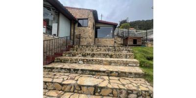 Se vende hermosa casa ubicada en la tranquila y acogedora ciudad de La Calera, en el departamento de Cundinamarca. Con una área total de 530 M2, esta propiedad cuenta con un terreno espacioso y una construcción de 186 M2, con una área privada de 170 M2. Perfecta para aquellos que buscan un hogar cómodo y amplio, esta casa cuenta con 2 habitaciones y 2 baños, ideal para una familia pequeña o parejas que deseen tener un espacio propio.

Al ingresar a la casa, notarás su agradable ambiente y su distribución bien pensada. De inmediato, podrás apreciar que esta propiedad admite mascotas, lo que la hace perfecta para quienes tienen amigos peludos en el hogar. Además, cuenta con una biblioteca/estudio, perfecta para teletrabajar o para aquellos que aprecian tener un espacio tranquilo para lectura o estudio.

Con clósets en las habitaciones, podrás guardar tus pertenencias de manera ordenada y práctica. Además, esta casa destaca por su maravillosa vista panorámica, una característica que te permitirá disfrutar de la belleza natural de La Calera. Y para los días fríos, podrás disfrutar de una cálida chimenea en el salón principal.

Otras características internas de esta propiedad incluyen un citófono/intercomunicador, una útil despensa para guardar tus víveres y otros objetos, lo que te ayudará a mantener tu hogar organizado. En cuanto a las características externas, la casa se encuentra en un acceso pavimentado, lo que facilita el tránsito en la zona.

Esta casa también cuenta con un área social, ideal para recibir a tus seres queridos y compartir momentos especiales. Además, cuenta con un cochera/garaje y una plaza de aparcamiento adicional, lo que te dará comodidad para estacionar tus vehículos. La ubicación también es favorable, con parques cercanos para pasear o hacer ejercicio.

Otros beneficios de esta propiedad incluyen un patio para disfrutar del aire libre, una portería/recepción y servicio de vigilancia para tu seguridad y tra