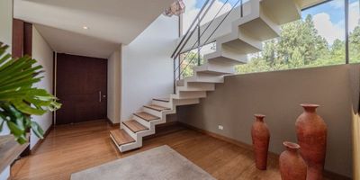 Casa con área de terreno de 1.095 m2, área construída de 280 m2 con excelente ubicación con vista al bosque y a la represa de San Rafael. La casa con excelente iluminación y amplios espacios, distribuidos en dos pisos; en el primer piso encontramos la sala con acceso a una terraza BBQ,  lineal de unos 40 mts aproximadamente y chimenea, comedor independiente, cocina semi abierta con espacio para un comedor auxiliar, zona de lavandería independiente, cava de vinos, baño social y espacio abierto para una sala auxiliar y estudio. En el segundo piso encontramos dos habitaciones auxiliares con baño externo y la alcoba principal con acceso a una agradable terraza, baño privado y amplio vestier;  family room con chimenea y linda vista exterior.
La casa se complementa con 3 parquederos independientes y depósitos (interno y externo)
El conjunto con amplios espacios de circulación, gimnasio, cancha de tenis, zona infantil, guardería y salón de reuniones.