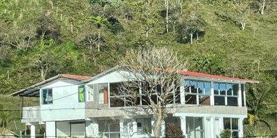 Casa campestre de dos niveles con 220 m² construidos, cinco habitaciones y amplio salón en el segundo piso. Ubicada en Guatapé, vereda El Roble – sector El Cristalino, rodeada de naturaleza, cerca de una quebrada cristalina y un sendero ecológico que conduce a hermosas cascadas. Arriendo mensual: $2.800.000.