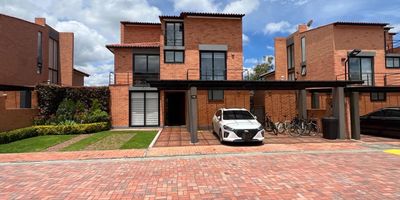 Codigo 19413. Viva con lujo, amplitud y exclusividad en esta espectacular casa de 3 niveles, ubicada en un condominio campestre con completas zonas sociales y deportivas. En un lote de 460 m² y con 329.5 m² construidos, esta propiedad ofrece diseño moderno y comodidad en cada espacio. En el primer nivel encontrará un hall de entrada, sala de TV, baño social, sala con chimenea a gas automática, comedor, cocina abierta súper amplia, cuarto y baño de servicio con salida a zona de lavandería y jardín con semipérgola. El segundo nivel cuenta con una elegante habitación principal con baño, vestier y salita privada, además de dos habitaciones adicionales con baño. El tercer nivel ofrece un amplio estudio, una habitación de gran tamaño con baño completo y un depósito. La casa se complementa con puertas y ventanas termoacústicas, parqueadero techado para tres vehículos y acceso directo desde allí a la puerta principal y la cocina. El condominio ofrece un estilo de vida inigualable con cancha de tenis en polvo de ladrillo, cancha múltiple, parque infantil, cancha de voleibol en grama, piscina temperada, jacuzzi, zonas húmedas con turco, gimnasio completamente dotado, salón de fiestas, sala de juegos con billar, pool y ping pong, sendero peatonal de 850 mts y un sistema de seguridad con circuito cerrado de televisión. Una oportunidad única para quienes buscan confort, exclusividad y calidad de vida.