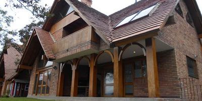 Casa de tres niveles, sala comedor y estudio con biblioteca, cinco habitaciones cada una con baño y chimenea, tres parqueaderos