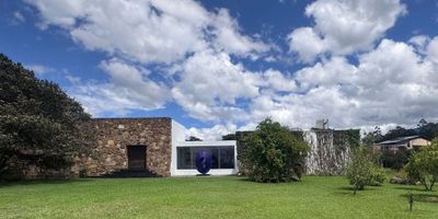 Excepcional oportunidad de inversión en finca campestre ubicada en la pintoresca Villa de Leyva, a solo 5 kilómetros del centro urbano y a 10 minutos en automóvil. El acceso es cómodo y directo, a través de la vía que conduce a la estación de bomberos, a 600 metros de la Hacienda La Rosita.
El terreno cuenta con una extensión de 20.854 m², ofreciendo un entorno de serenidad, confort y contacto con la naturaleza. La propiedad alberga dos residencias de diseño moderno y acabados de alta calidad:
• Residencia principal: área de 400 m², sala y comedor integrados, cocina contemporánea, sala social con chimenea, terraza con comedor al aire libre, baño social, habitación para huéspedes con baño privado, estudio, y habitación principal con baño en suite, vestidor y acceso a terraza privada.
• Casa de huéspedes: área de 10.427 m², ubicada frente a un lago, con amplia terraza que funciona como comedor, sala y comedor interiores, cocina moderna, dos habitaciones (una con baño privado) y grandes ventanales con vistas a las zonas verdes.
Adicionalmente, la finca incluye una casa para el personal de servicio con un área de 73 m², zona de estacionamiento con 93 m² y un depósito.
Para el disfrute y relajación de sus residentes, la propiedad ofrece un entorno natural con bosque de eucaliptos, árboles frutales y una huerta.
Esta finca representa una inversión ideal para quienes buscan un espacio exclusivo, tranquilo y en armonía con la naturaleza.