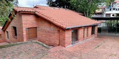 CASA-LOTE EN VENTA CASABLANCA SUBA. Área de lote 1.450m2, área construida 300m2 aprox. Magnifica ubicación contiguo al exclusivo conjunto residencial Torreladera, frente al parque Casablanca, ideal para construir edificio de hasta seis pisos o vivir rodeado por naturaleza en su  hermosa casa principal compuesta por dos niveles, cuatro alcobas con closet, cuatro baños, estudio, zona de ropas independiente, espacio para oficina o gimnasio, terraza, además cuenta con un aparta-estudio independiente de una alcoba, sala comedor un baño, kiosko con cocineta y zona de ropas. La propiedad cuenta con tanque de reserva de agua, cuatro parqueaderos cubiertos y un parqueadero descubierto.