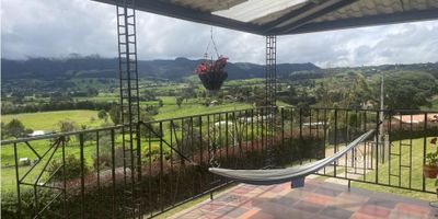 Rent-A-House arrienda hermosa casa campestre, ideal para disfrutar de la tranquilidad de vivir en armonia con la naturaleza. Con una amplia disposicion abierta de sala con chimenea, comedor, estudio, zona de juegos o family room, cocina, y una estupenda terraza y balcon  que permiten apreciar de una formidable vista. La via desde La Calera esta totalmente pavimentada. Agenda tu cita. - 25-2