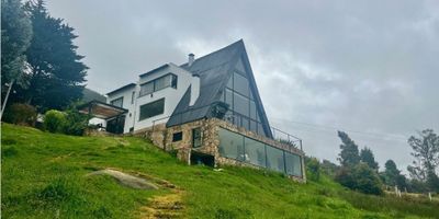 Rentahouse Vende exclusiva Casa Campestre Multinivel  en  Condominio Rio Grande, en La Calera, esta propiedad representa una oportunidad verdaderamente excepcional para adquirir una Casa que fusiona comodidad con la incomparable tranquilidad de la naturaleza. Remodelada, con  400 mts construidos, en un lote cercano a los 5.000 mts  ,de espacios generosos, concebidos para el entretenimiento y para los momentos familiares más íntimos, tiene actualización completa de tuberías y redes eléctricas lo cual garantiza  eficiencia,  seguridad y tranquilidad de los residentes, eliminando  preocupaciones comunes asociadas a propiedades de mayor antigüedad. La Casa goza del privilegio inigualable de tener el Río Teusacá como su límite natural, no es solo un telón de fondo escénico, sino una parte integral de la identidad de la propiedad, ofreciendo el sonido constante y relajante del agua, Te imaginas  despertar con el suave murmullo del agua, que esperas? LLAMA YA!!!!! - 25-1544