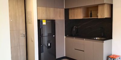 Este apartamento combina diseño contemporáneo, funcionalidad y confort en 37 m² ideales para una o dos personas que buscan un espacio moderno, luminoso y bien ubicado en Bogotá. Su distribución abierta integra sala, comedor y cocina en un ambiente elegante con un ventanal-balcón que aporta luz natural y vista al noroccidente. La cocina es moderna y práctica, equipada con estufa de inducción, nevera, extractor y amplios gabinetes. A diferencia de otros apartamentos de este tamaño, cuenta con una zona de lavado independiente y cerrada, con lavadero y espacio para lavadora-secadora. La habitación principal ofrece privacidad y acomoda cama doble o queen. El baño tiene acabados de alta calidad y una ducha amplia. El edificio ofrece gimnasio, terraza panorámica, coworking, salón social y recepción 24 horas.